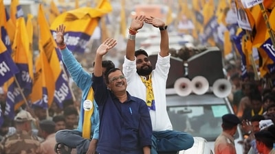 Delhi Chief Minister and Aam Aadmi Party (AAP) National Convener Arvind Kejriwal waves to the crowd during the roadshow for the upcoming Gujarat Assembly elections, in Halol. 