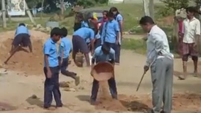 Screengrab from the viral video of school students filling potholes. Screengrab from the viral video of school students filling potholes.
