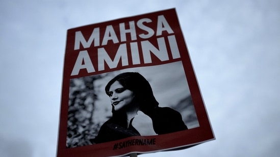 Iran Anti-Hijab Protests: A woman holds a placard with a picture of Iranian woman Mahsa Amini during a protest against her death. Iran Anti-Hijab Protests: A woman holds a placard with a picture of Iranian woman Mahsa Amini during a protest against her death.