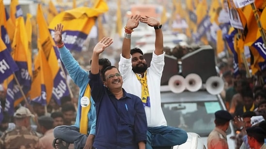 Delhi Chief Minister and Aam Aadmi Party (AAP) National Convener Arvind Kejriwal waves to the crowd during the roadshow for the upcoming Gujarat Assembly elections, in Halol.