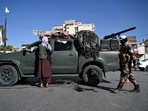Afghanistan: Taliban fighters stand guard as they block a road near Kabul.