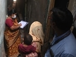 A woman (C) cradling her child interacts with municipal staff during a survey inside a slum following a measles outbreak in Mumbai on Wednesday. (AFP) A woman (C) cradling her child interacts with municipal staff during a survey inside a slum following a measles outbreak in Mumbai on Wednesday. (AFP)