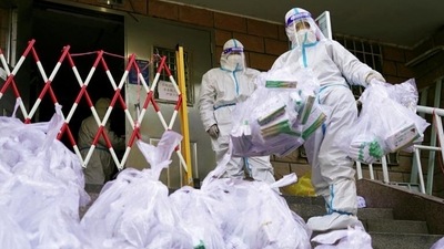 Covid In China: Workers in protective suits prepare to enter a building under lockdown. (Reuters)