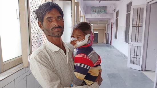 Riya, who was bitten by a dog on both of her cheeks, with her father at MMG Hospital in Ghaziabad on November 22. (Sakib Ali/HT Photo)