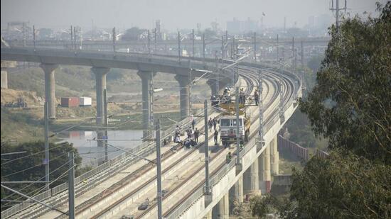 The rapid rail bridge and the rapid rail line over the Hindon river in Ghaziabad have been installed and the workers of the rapid rail are working on the electric poles, in Ghaziabad on November 19. (Sakib Ali/HT Photo)