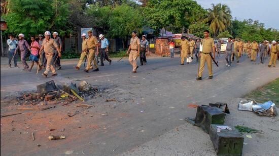 Security personnel walk past burnt ballot boxes after unknown people ransacked a polling station during 2018 panchayat polls. (PTI)