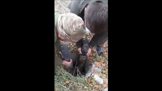 Ukrainian soldiers rescuing a dog that has fallen inside this deep pit. (Twitter/@Gerashchenko_en)