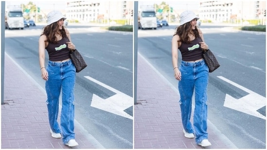 The pants feature a high-rise waistline, distressed cut-outs on the side, baggy fitting, and a floor-grazing hem. Sharvari wore the ensemble with minimal accessories, including white chunky lace-up sneakers, a matching white bucket hat, pretty gold hoop earrings, and a Louis Vuitton shoulder bag.(Instagram)