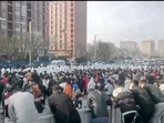 Protesters face off against security personnel in white protective clothing at the factory compound operated by Foxconn Technology Group who runs the world's biggest Apple iPhone factory in Zhengzhou in central China's Henan province. (AP) Protesters face off against security personnel in white protective clothing at the factory compound operated by Foxconn Technology Group who runs the world's biggest Apple iPhone factory in Zhengzhou in central China's Henan province. (AP)