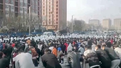Protesters face off against security personnel in white protective clothing at the factory compound operated by Foxconn Technology Group who runs the world's biggest Apple iPhone factory in Zhengzhou in central China's Henan province. (AP) Protesters face off against security personnel in white protective clothing at the factory compound operated by Foxconn Technology Group who runs the world's biggest Apple iPhone factory in Zhengzhou in central China's Henan province. (AP)