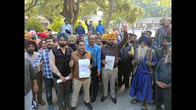 At a rally held by the Sanjha Mulajam Manch Punjab and UT at Sector 17 Chandigarh, the protesting employees tore the copies of the government notification. (HT photo)