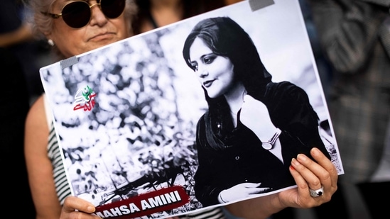 A protestor holds a portrait of Iranian Mahsa Amini, during a rally in support of the demonstrators in Iran in Paris. (AFP file)