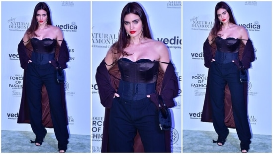 Gabriella Demetriades attended the event dressed in a black corset top, a cape jacket and straight-fitted pants. She styled the outfit with bold red lips, peep-toe heels, dangling earrings, open tresses and a mini handbag.(HT Photo/Varinder Chawla)