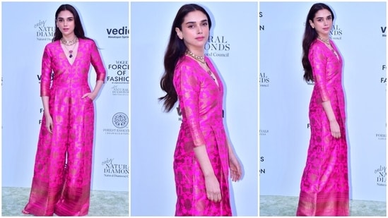Aditi Rao Hydari put a traditional twist to a jumpsuit by donning a rani pink brocade embroidered ensemble featuring quarter-length sleeves, a deep V-neck, and flared pants. She styled the ensemble with statement jewels, strappy heels, minimal makeup and open tresses.(HT Photo/Varinder Chawla)