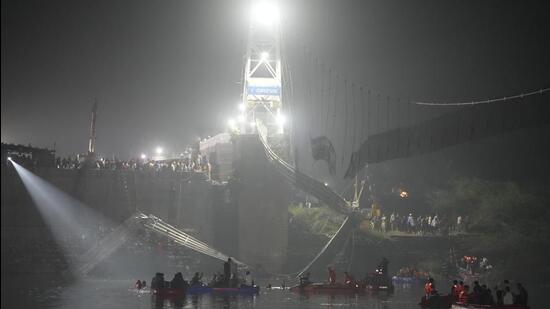 Rescuers on boats search in the Machchu river next to a cable suspension bridge that collapsed in Morbi town of western state Gujarat, India, Monday, Oct. 31, 2022. The century-old cable suspension bridge collapsed into the river Sunday evening, sending hundreds plunging in the water, officials said. (AP Photo/Ajit Solanki) (AP)