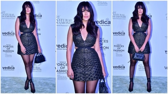 Mrunal Thakur attended the Forces Of Fashion event in a sleeveless jacquard mini dress featuring side cut-outs on the waist, a plunging V neckline, and a short hem length. She wore the ensemble with sheer black stockings, embellished boots, a top handle bag, and statement rings. Lastly, open wavy tresses with light bangs, pink lip shade, subtle smoky eye shadow, blushed cheeks, beaming highlighter and mascara-adorned lashes completed the glam picks.(HT Photo/Varinder Chawla)
