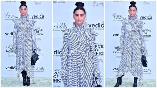 Farhan Akhtar's wife, Shibani Dandekar, attended Vogue's Forces Of Fashion event in a white midi dress decked with a black logo print, exaggerated collar and a flowy silhouette.  High-length boots, a top handle bag, a high bun and nude-palette makeup gave the finishing touch.(HT Photo/Varinder Chawla)