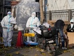 Workers in protective clothing control access into a community under lockdown in Beijing.(AP) Workers in protective clothing control access into a community under lockdown in Beijing.(AP)