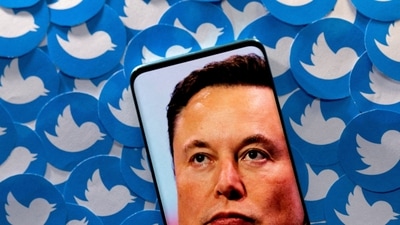 An image of Elon Musk is seen on a smartphone placed on printed Twitter logos in this picture illustration. (REUTERS file)