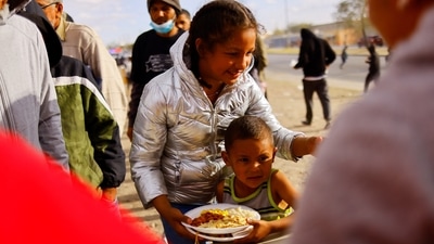 Migrant children from Venezuela receive Thanksgiving Day meals at a camp on the banks of the Rio Bravo river in Ciudad Juarez, Mexico. (REUTERS)
