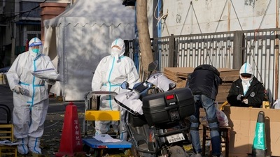 Workers in protective clothing control access into a community under lockdown in Beijing. (AP) Workers in protective clothing control access into a community under lockdown in Beijing. (AP)