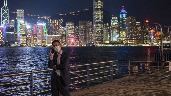 Hong Kong: A man talks on his phone in front of the skyline in Hong Kong.(AP File)