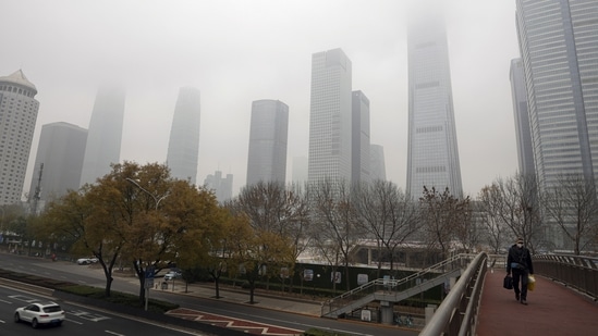 China: A man wearing a face mask walks on a pedestrian bridge. (AP)