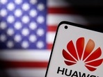 Smartphone with a Huawei logo is seen in front of a US flag in this illustration.