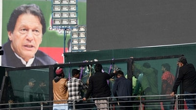 Workers install a bullet proof glass shield on the main stage of the venue ahead an anti-government rally by former Prime Minister Imran Khan. (AFP)