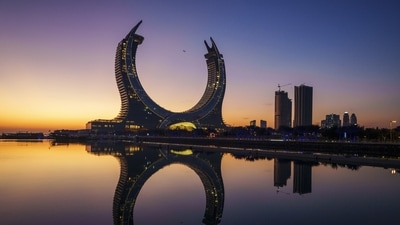 A plane flies over the Crescent Tower Lusail during sunrise in Lusail, Qatar, on Thursday. (AP) A plane flies over the Crescent Tower Lusail during sunrise in Lusail, Qatar, on Thursday. (AP)