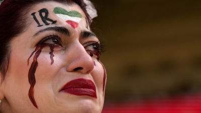 An Iranian woman breaks into tears after security personnel seized her flag reading "Woman Life Freedom" before the start of the World Cup group B soccer match between Wales and Iran, at the Ahmad Bin Ali Stadium in Al Rayyan, Qatar, on Friday. (AP) An Iranian woman breaks into tears after security personnel seized her flag reading "Woman Life Freedom" before the start of the World Cup group B soccer match between Wales and Iran, at the Ahmad Bin Ali Stadium in Al Rayyan, Qatar, on Friday. (AP)
