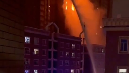 Covid In China: Firefighters spray water on a fire at a residential building in Urumqi in western China's Xinjiang. (AP)