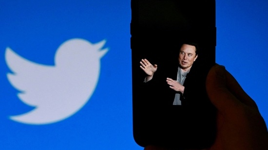 (FILES) In this file photo taken on October 4, 2022, a phone screen displays a photo of Elon Musk with the Twitter logo shown in the background, in Washington, DC. - (AFP)