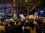 Protesters raise blank sheets of white paper as a symbol of dissent against China's strict Covid lockdown rules. 
