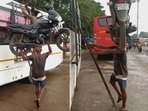 The man is balancing the bike on his head and climbing the ladder to reach the roof of the bus. (Twitter/@Gulzar_sahab) The man is balancing the bike on his head and climbing the ladder to reach the roof of the bus. (Twitter/@Gulzar_sahab)