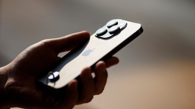 A man holds an iPhone 14 (REUTERS)