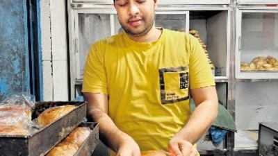 Adnan using the flame from two mom candles to seal the plastic packs of freshly baked buns Adnan using the flame from two mom candles to seal the plastic packs of freshly baked buns
