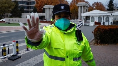 A security officer attempts to prevent pictures from being taken, at a gate to Tsinghua University in Beijing. (Reuters) 