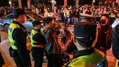 Police officers confront a man as they block Wulumuqi street, named for Urumqi in Mandarin, in Shanghai on Sunday in the area where protests against China's zero-Covid policy took place the night before following a deadly fire in Urumqi, the capital of the Xinjiang region. (AFP) Police officers confront a man as they block Wulumuqi street, named for Urumqi in Mandarin, in Shanghai on Sunday in the area where protests against China's zero-Covid policy took place the night before following a deadly fire in Urumqi, the capital of the Xinjiang region. (AFP)