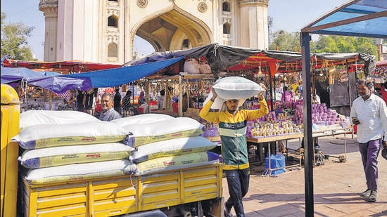 A worker carries a sack of refined wheat flour towards a hotel in front of the landmark Charminar monument in Hyderabad, India, Thursday, Nov. 17, 2022. (AP Photo/Mahesh Kumar A.) (AP)