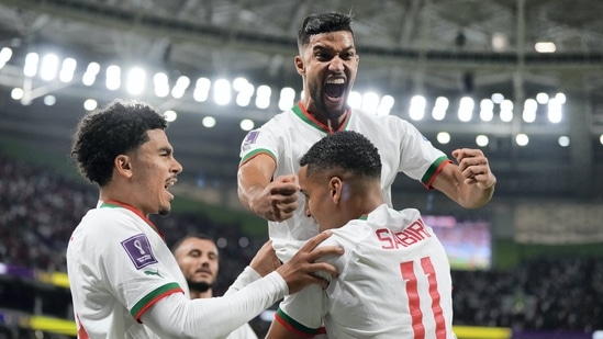 Morocco's Abdelhamid Sabiri (11) celebrates his goal with teammates Zakaria Aboukhlal, left, and Yahya Jabrane, top, after scoring during the FIFA World Cup group F match between Belgium and Morocco, at the Al Thumama Stadium in Doha.(AP)