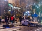 People stand next to a burned out car during riots in Brussels, Sunday, Nov. 27, 2022. Police had to seal off parts of the center of Brussels and moved in with water cannons and tear gas to disperse crowds following violence during and after Morocco's 2-0 win over Belgium at the World Cup.(AP) People stand next to a burned out car during riots in Brussels, Sunday, Nov. 27, 2022. Police had to seal off parts of the center of Brussels and moved in with water cannons and tear gas to disperse crowds following violence during and after Morocco's 2-0 win over Belgium at the World Cup.(AP)