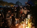 Demonstrators light candles for the victims of a deadly fire in the city of Urumqi during a protest in Beijing, China, on November 27. (Bloomberg)