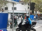 People wait near barriers set up at an intersection along Wulumuqi road, where protests against coronavirus disease (COVID-19) curbs took place.