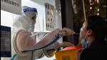 A health worker takes a swab sample from a woman to test for Covid-19 in the Jing’an district in Shanghai, China on Monday. (AFP) A health worker takes a swab sample from a woman to test for Covid-19 in the Jing’an district in Shanghai, China on Monday. (AFP)