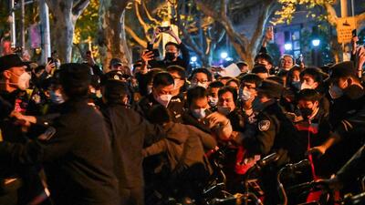 Police and people are pictured during some clashes in Shanghai on Sunday, where protests against China’s ‘zero-Covid’ policy took place the night before following a deadly fire in Urumqi, the capital of the Xinjiang region. (AFP’)