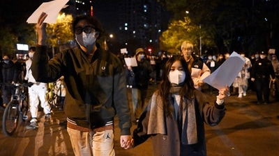 Protesters march along a street during a rally for the victims of a deadly fire as well as a protest against China's harsh Covid-19 restrictions in Beijing on November 28. (AFP) Protesters march along a street during a rally for the victims of a deadly fire as well as a protest against China's harsh Covid-19 restrictions in Beijing on November 28. (AFP)