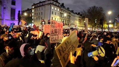 People protest against China's coronavirus disease (COVID-19) curbs in front of the Chinese embassy in London, Britain November 27, 2022 in this still image from a social media video.  Alexander Mak/via REUTERS  THIS IMAGE HAS BEEN SUPPLIED BY A THIRD PARTY. MANDATORY CREDIT. NO RESALES. NO ARCHIVES. (Alexander Mak via REUTERS)
