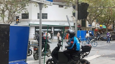 People wait near barriers set up at an intersection along Wulumuqi road, where protests against coronavirus disease (COVID-19) curbs took place. (REUTERS)