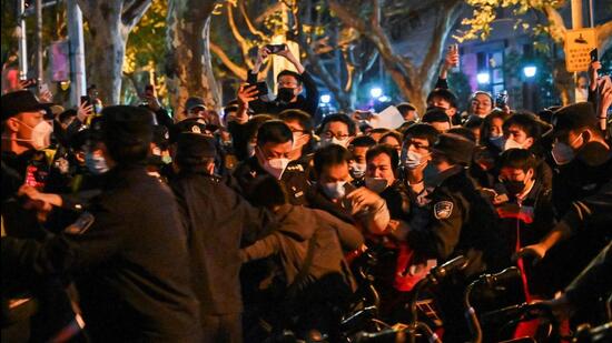 Police and people are pictured during some clashes in Shanghai on Sunday, where protests against China’s ‘zero-Covid’ policy took place the night before following a deadly fire in Urumqi, the capital of the Xinjiang region. (AFP’)